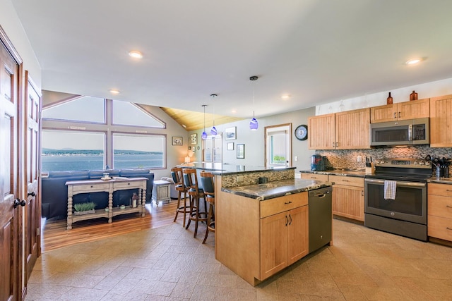 kitchen featuring plenty of natural light, appliances with stainless steel finishes, dark countertops, and tasteful backsplash