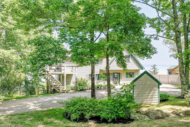 view of front of property with driveway, stairway, and fence