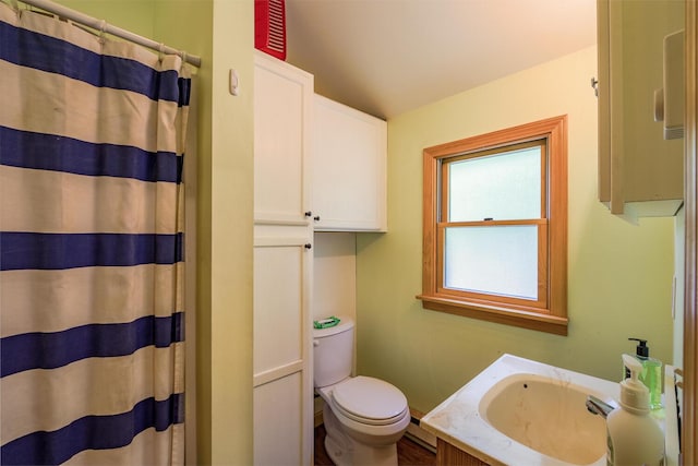 bathroom featuring a baseboard heating unit, curtained shower, vanity, and toilet