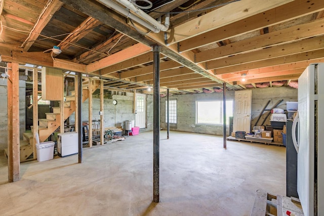 below grade area with stairway and freestanding refrigerator