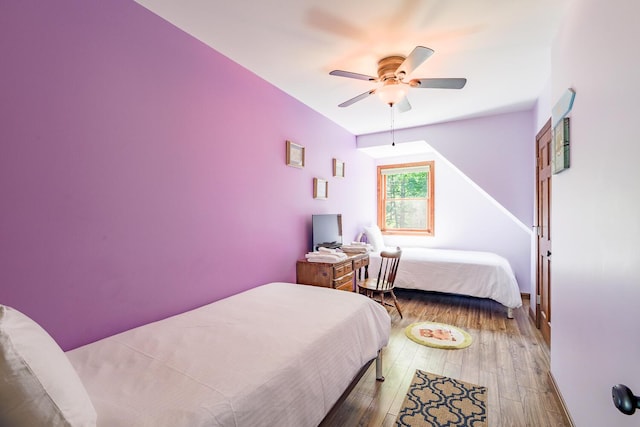 bedroom featuring baseboards, hardwood / wood-style flooring, and a ceiling fan