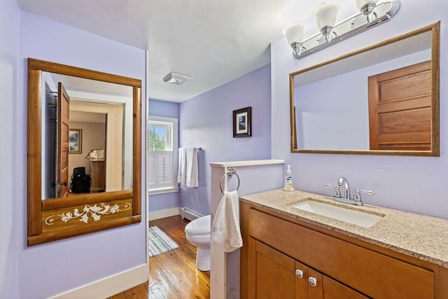 bathroom featuring toilet, vanity, a baseboard radiator, and hardwood / wood-style flooring