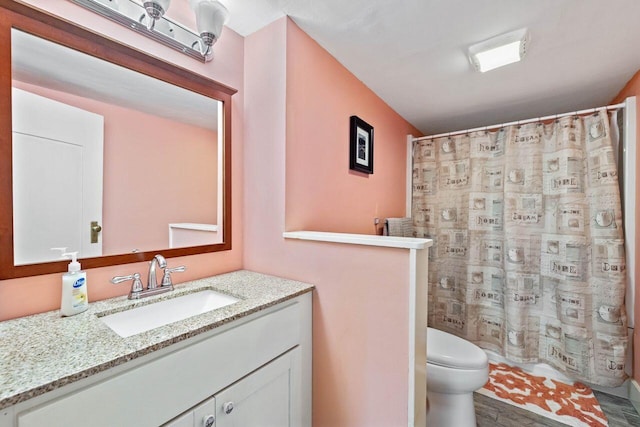 bathroom featuring a shower with curtain, vanity, and toilet