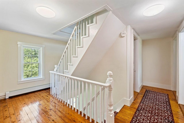 staircase featuring hardwood / wood-style floors and a baseboard radiator