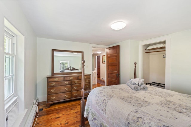 bedroom featuring dark hardwood / wood-style flooring, a wall mounted AC, and a closet