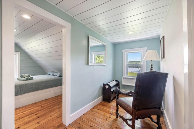 sitting room with lofted ceiling, light wood-type flooring, and wood ceiling