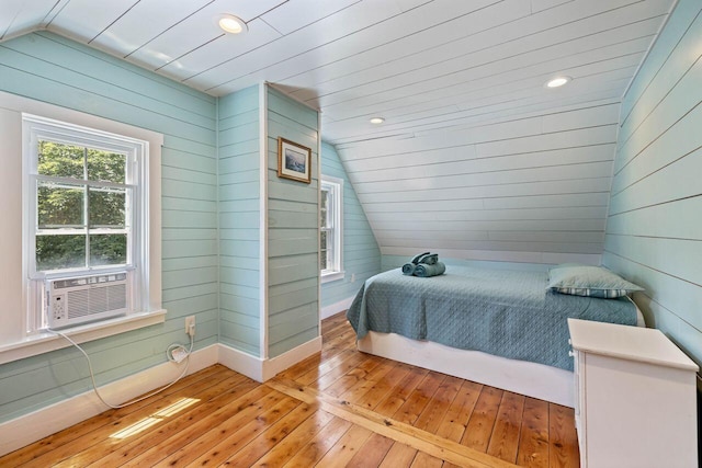 bedroom featuring cooling unit, light hardwood / wood-style floors, and vaulted ceiling