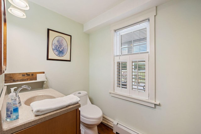 bathroom featuring vanity, a baseboard heating unit, and toilet