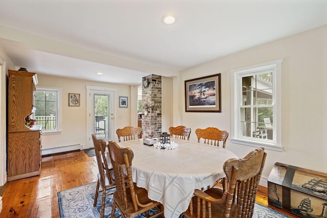 dining room featuring wood-type flooring and a baseboard heating unit