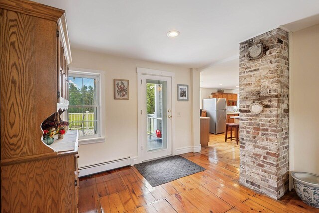 doorway to outside featuring light wood-type flooring and baseboard heating