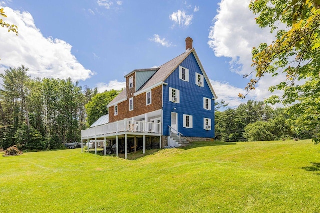 rear view of house with a lawn and a wooden deck