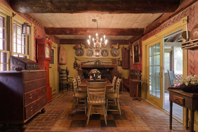 dining space featuring beamed ceiling, a healthy amount of sunlight, and a notable chandelier