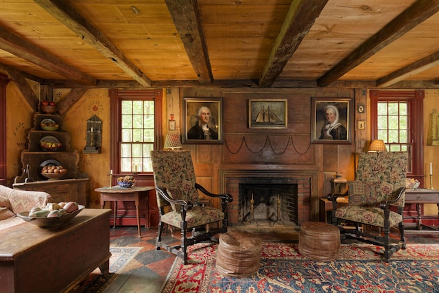 sitting room featuring wooden walls, a fireplace, beamed ceiling, and wood ceiling