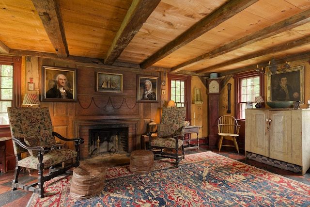 living area featuring beam ceiling, wood ceiling, and a wealth of natural light