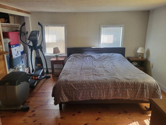 bedroom featuring a baseboard radiator and dark hardwood / wood-style floors