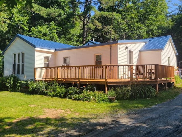 rear view of property with a yard and a wooden deck