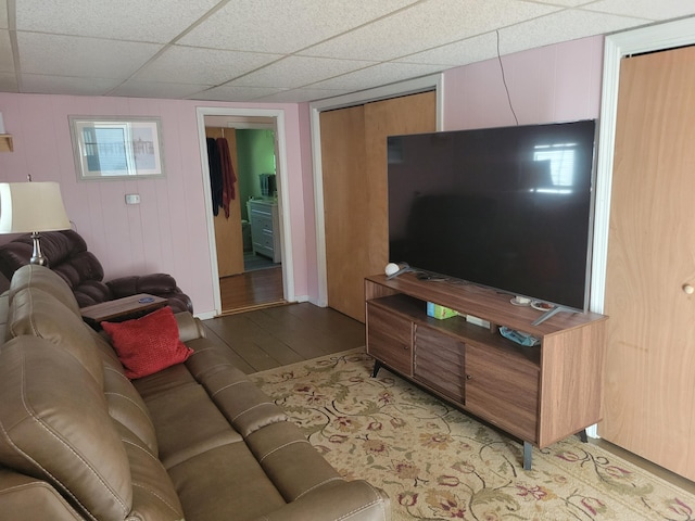 living room with a drop ceiling and light hardwood / wood-style floors