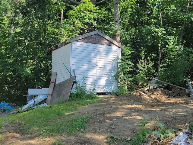 view of side of home featuring a shed