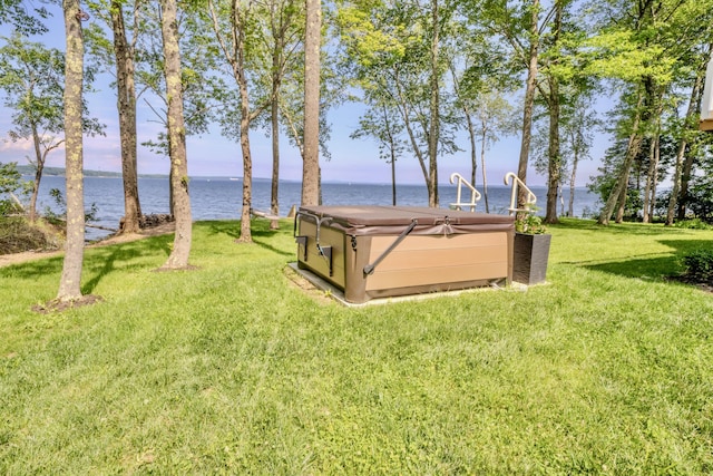 view of yard featuring a water view and a hot tub