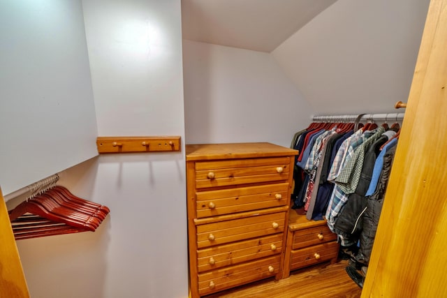 spacious closet with hardwood / wood-style floors and vaulted ceiling