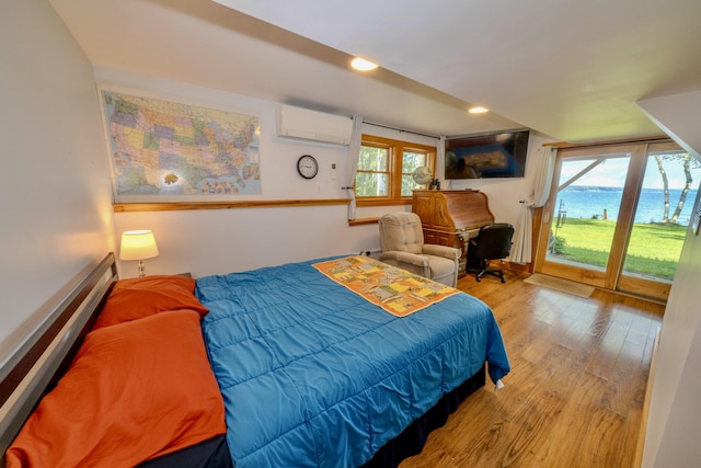 bedroom featuring a water view, access to exterior, multiple windows, and light hardwood / wood-style floors