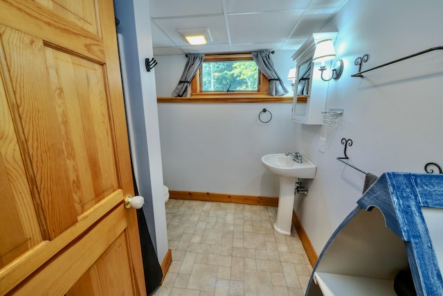 bathroom featuring a paneled ceiling and sink