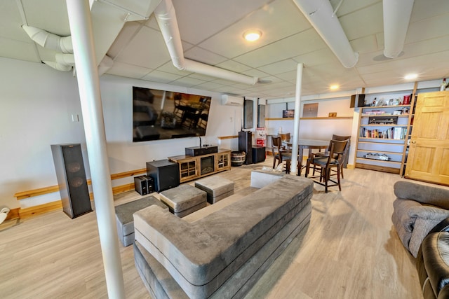 living room with hardwood / wood-style flooring and an AC wall unit