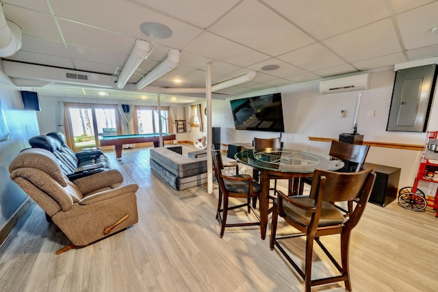 dining room with a drop ceiling, pool table, light hardwood / wood-style flooring, and a wall mounted AC