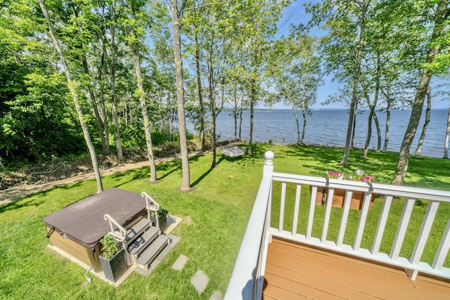 view of yard with a deck with water view and a covered hot tub