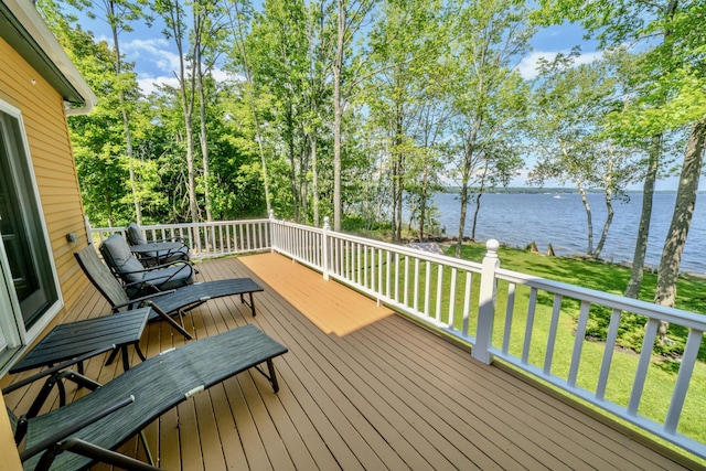 wooden terrace with a yard and a water view