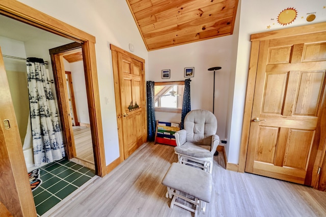 sitting room featuring vaulted ceiling, wood ceiling, and light hardwood / wood-style floors