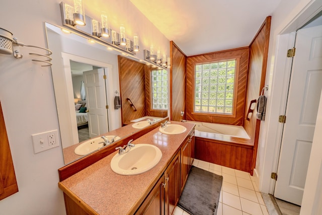 bathroom with a washtub, vanity, wood walls, and tile patterned flooring