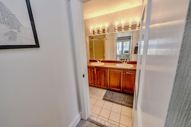 bathroom with walk in shower, tile patterned floors, and vanity