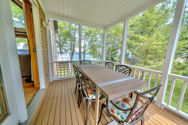 sunroom featuring a water view