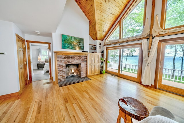 living room with a fireplace, high vaulted ceiling, a water view, hardwood / wood-style flooring, and wooden ceiling