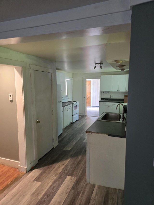 kitchen with white appliances, dark hardwood / wood-style floors, white cabinetry, and sink