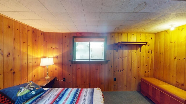 bedroom with carpet floors and wood walls