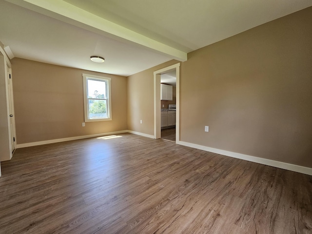 unfurnished room with beamed ceiling and hardwood / wood-style flooring