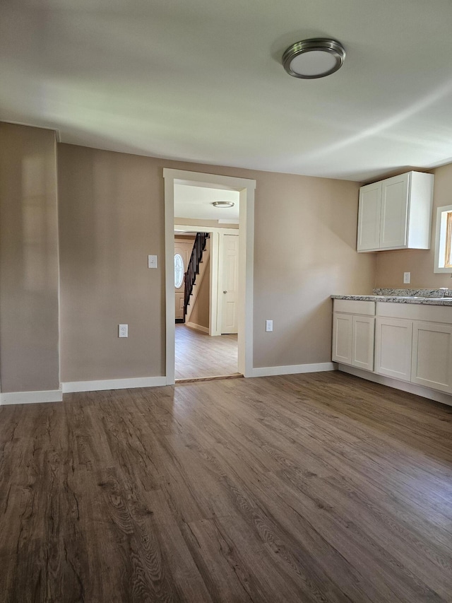 interior space featuring light stone counters, white cabinets, and light wood-type flooring