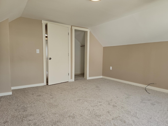 additional living space with carpet flooring and vaulted ceiling