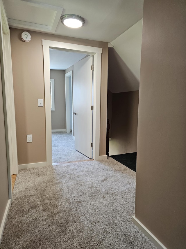 corridor featuring light colored carpet and vaulted ceiling