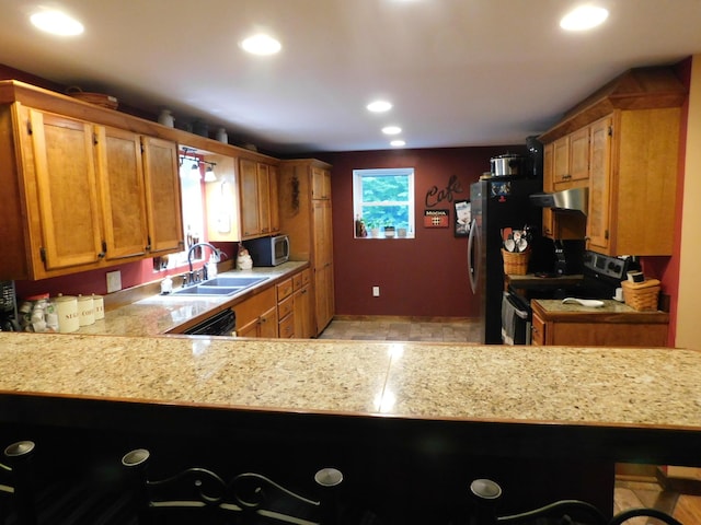 kitchen with sink, appliances with stainless steel finishes, and kitchen peninsula