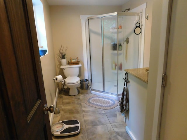 bathroom featuring an enclosed shower, vanity, and toilet