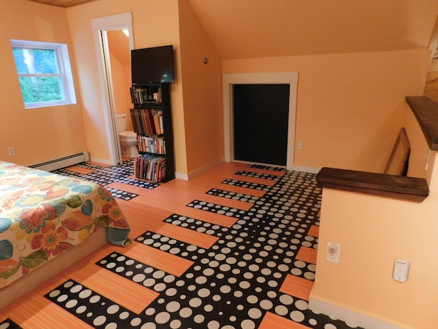 bedroom featuring a baseboard heating unit, lofted ceiling, connected bathroom, and hardwood / wood-style floors