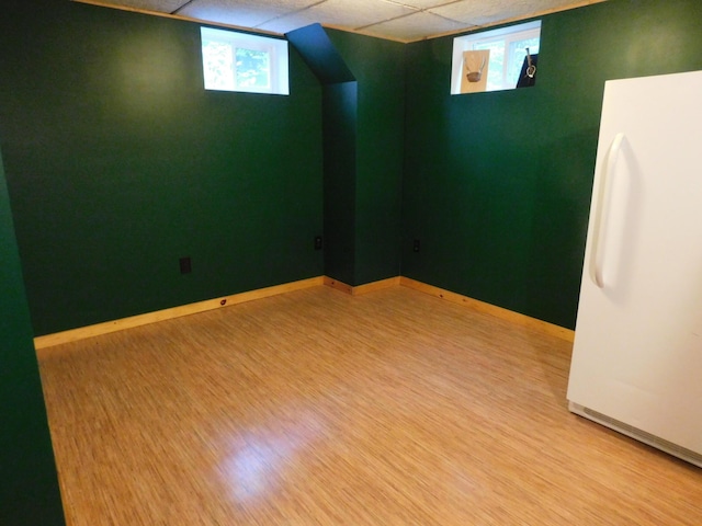 unfurnished room with a paneled ceiling and light wood-type flooring