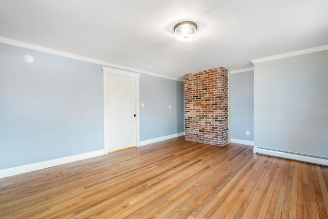 unfurnished room featuring a baseboard heating unit, crown molding, baseboards, and light wood-type flooring