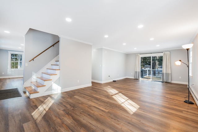 unfurnished living room with baseboards, wood finished floors, and stairs