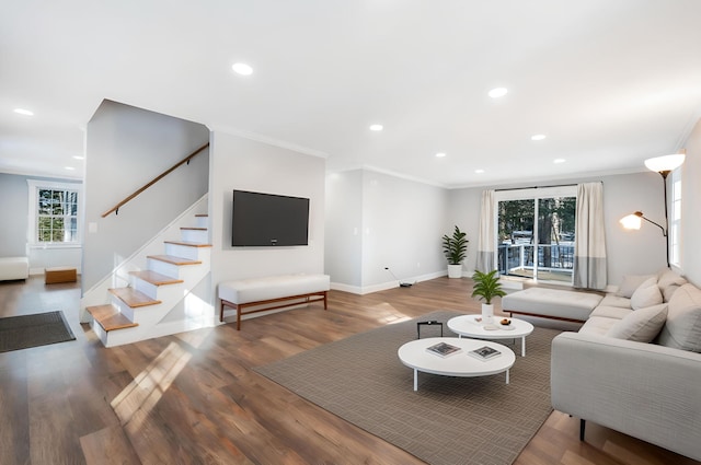 living area featuring stairway, wood finished floors, baseboards, recessed lighting, and crown molding