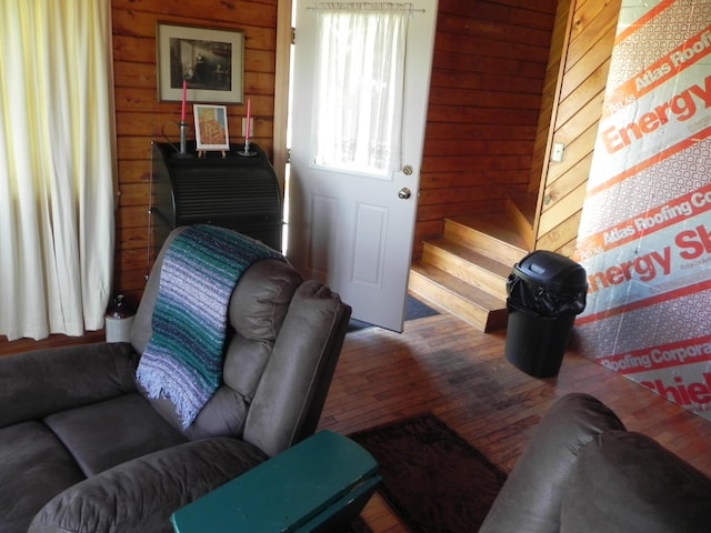 living room with wood-type flooring and wooden walls