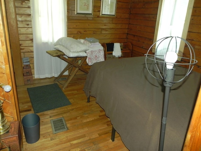 bedroom featuring wood walls and light hardwood / wood-style flooring